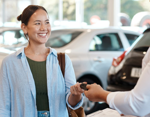 Client recevant les clés d’un véhicule dans une concession automobile