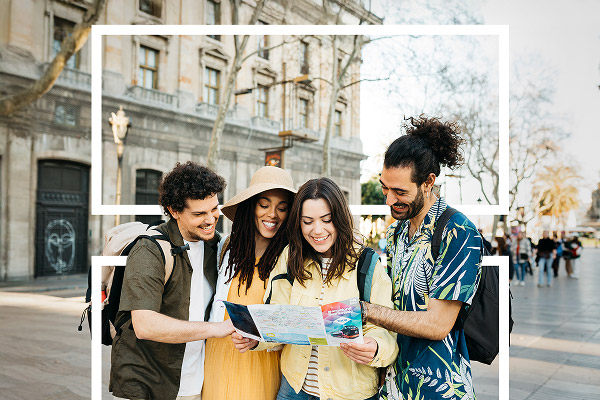 Groupe de jeunes voyageurs consultant une carte dans une rue à l’étranger
