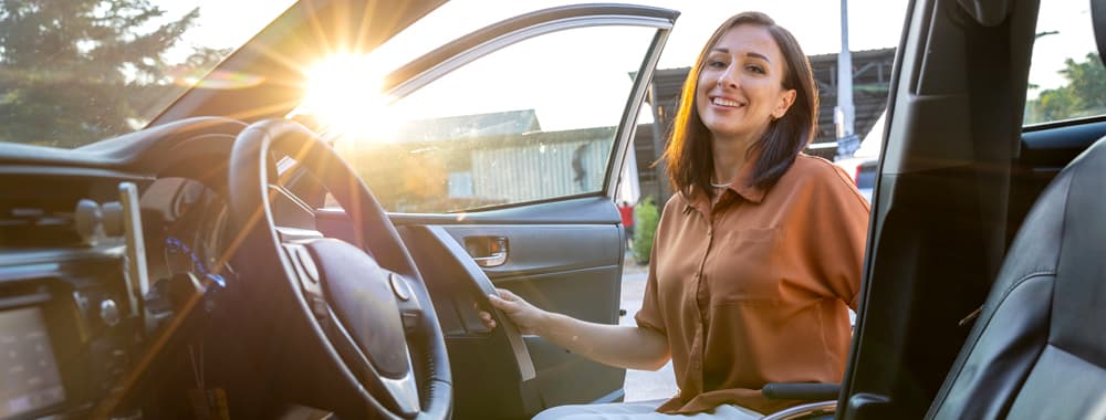 Conductrice qui monte dans son véhicule grâce à une assurance auto à la journée