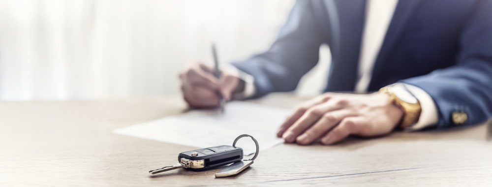 Homme remplissant un document pour son assurance auto